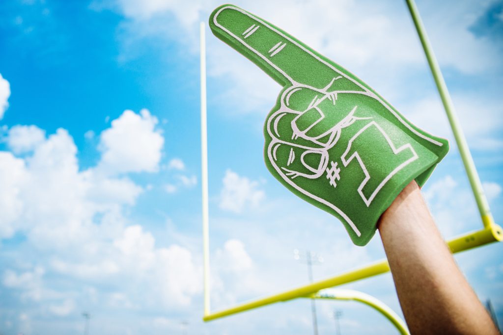 green foam number one finger in front of goal post on football field