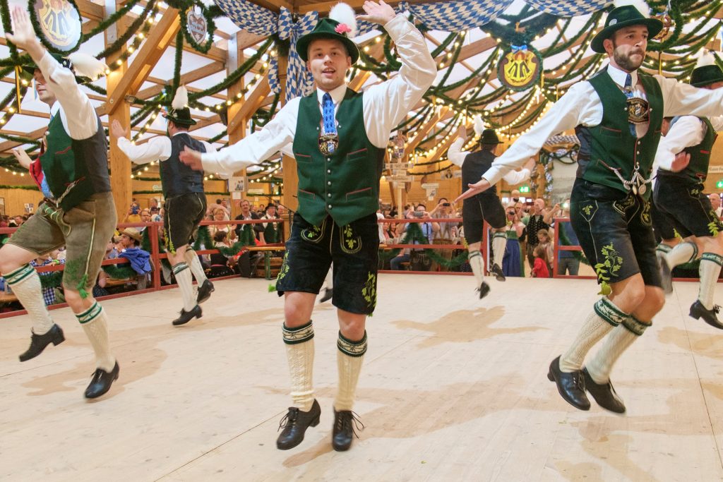 men dancing in traditional lederhosen on stage