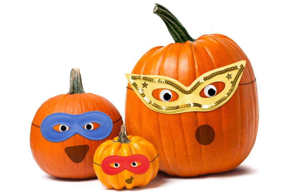 three pumpkins with super hero masks on and googly eyes