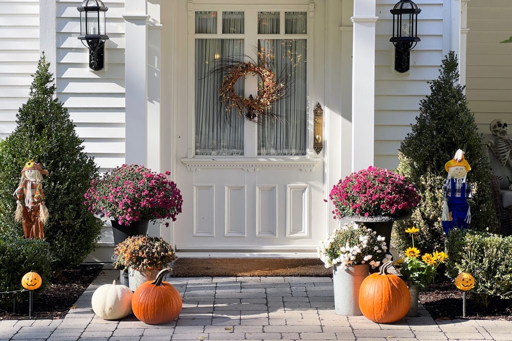 white house front porch decorated for halloween in the afternoon light