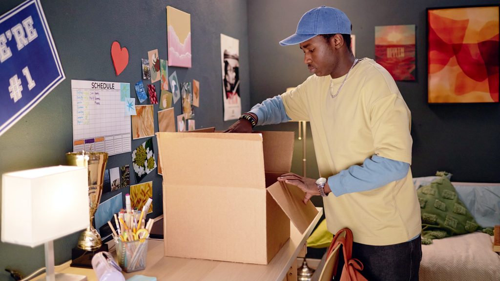 Guy in room opening a large package.