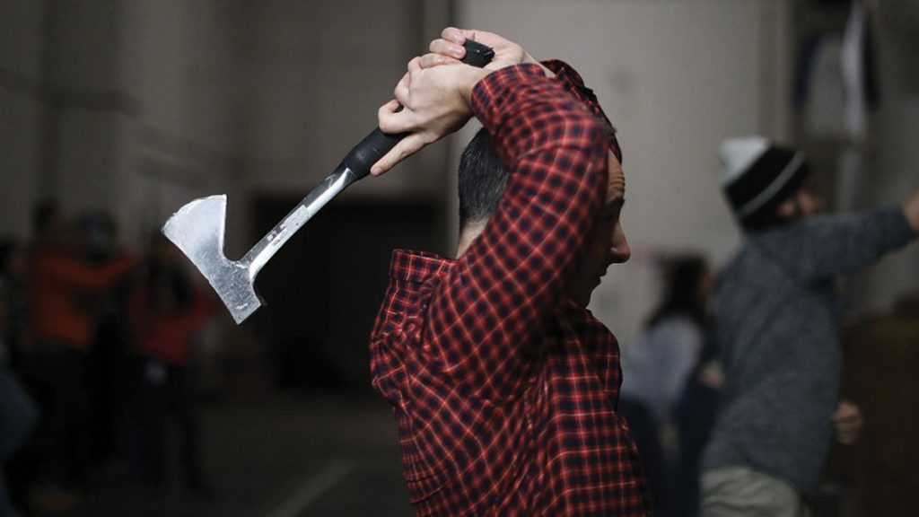 Man competing in axe throwing.