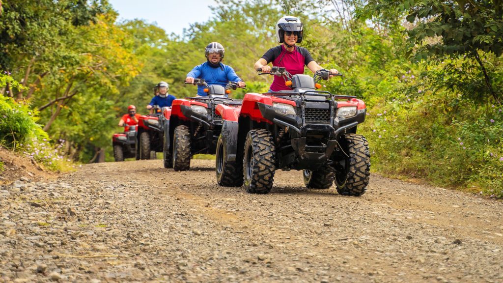 People on a trail riding ATVs.