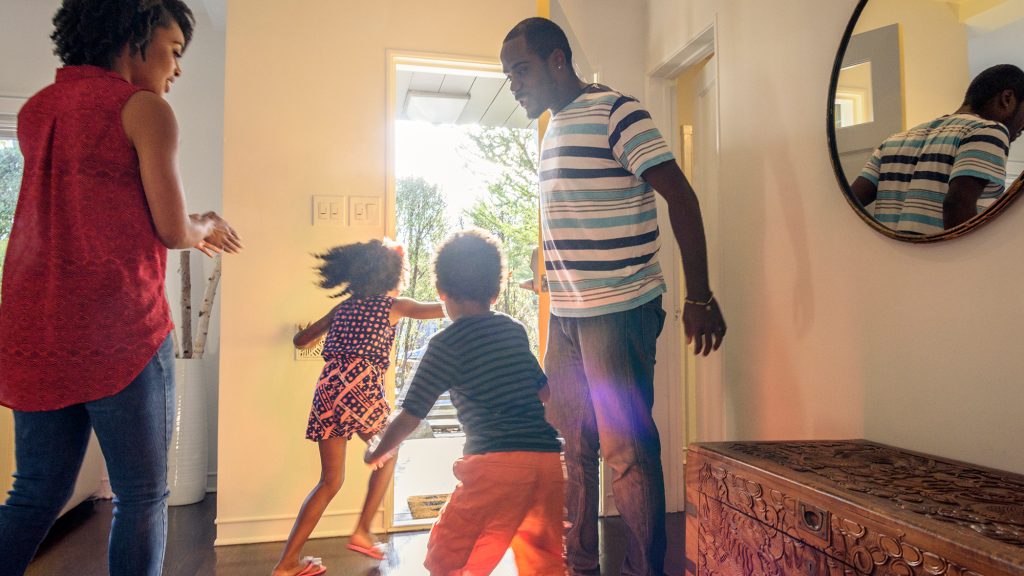 Family of four running out the front door.