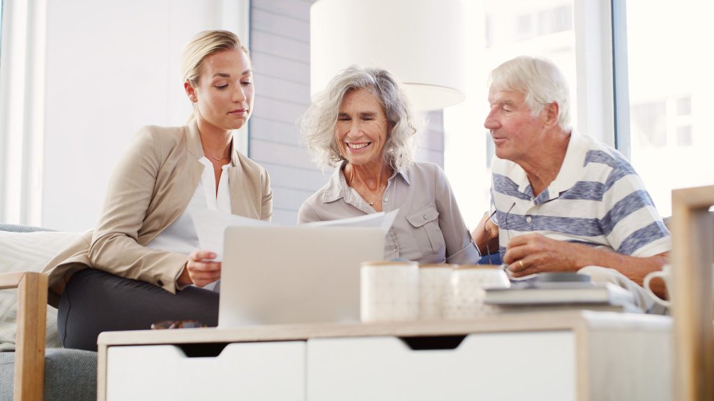 One younger woman and an older couple reviewing documents together.