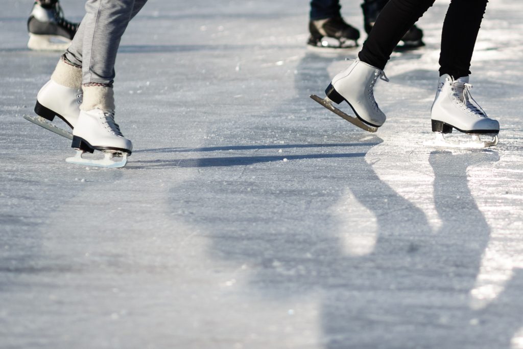 Close up of people ice skating on a rink.
