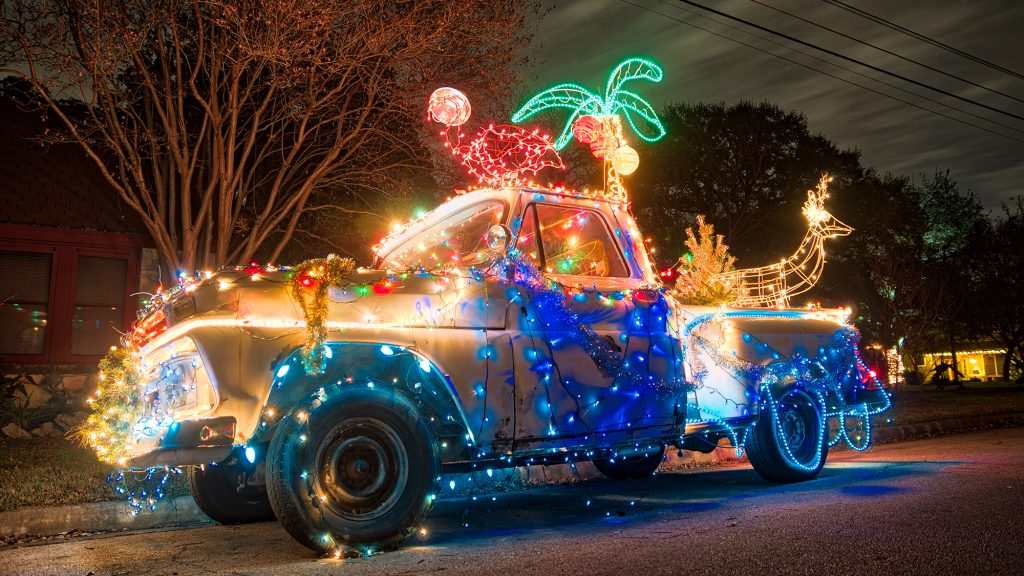 Car decorated with a lot of Christmas lights and decorations.