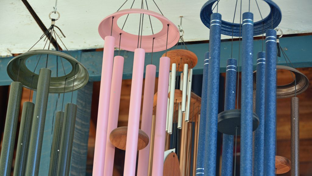 Many wind chimes hanging in a store.