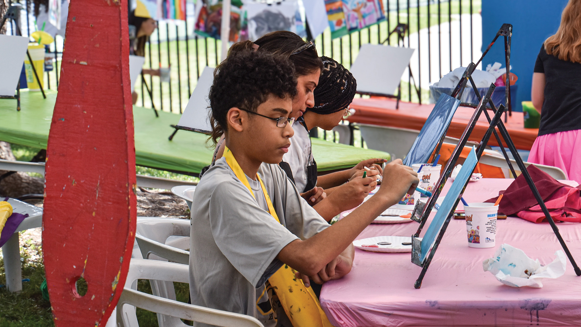 Kid painting at an activity table at the Cottonwood Art Festival.