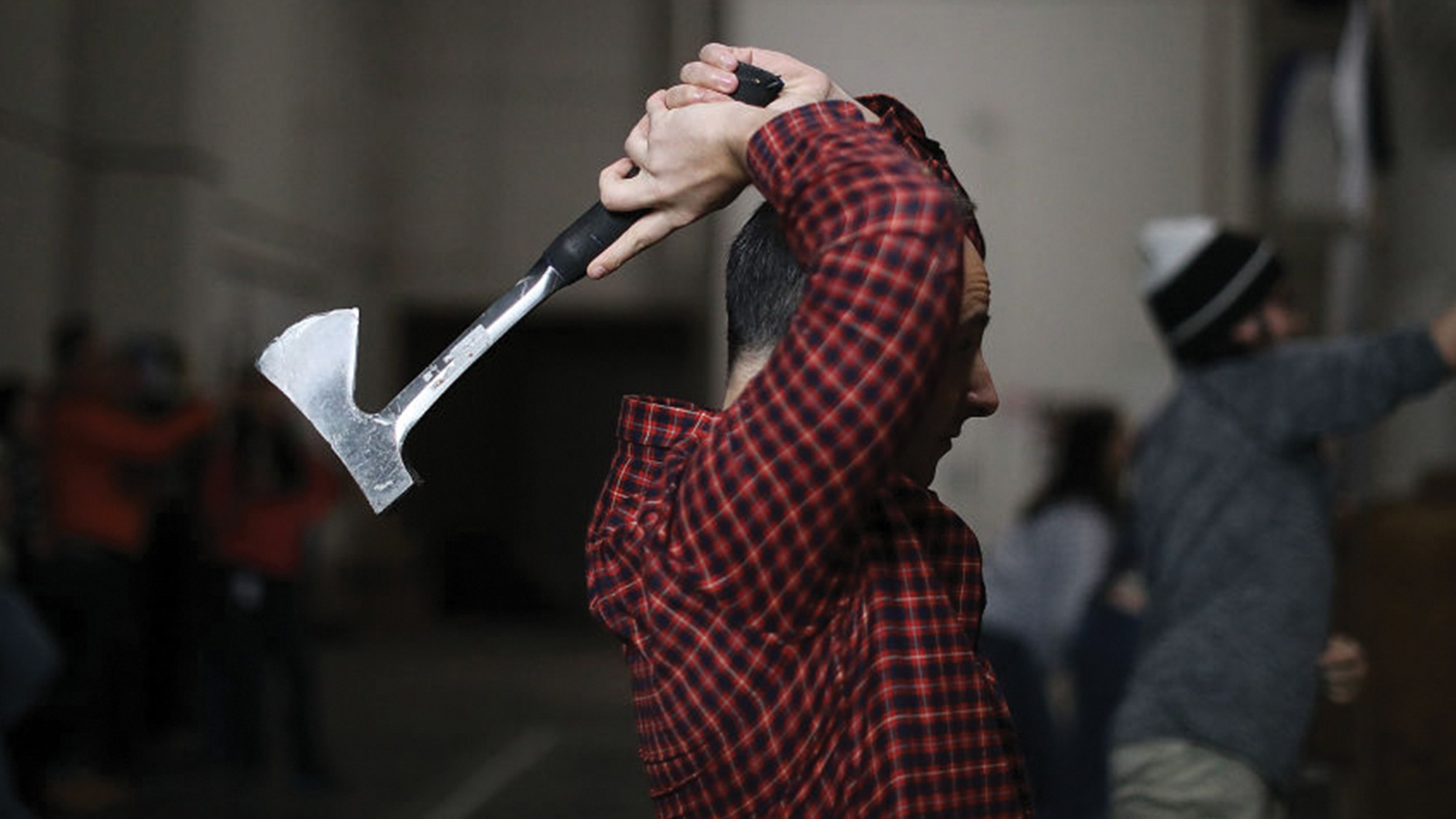 Man competing in axe throwing.