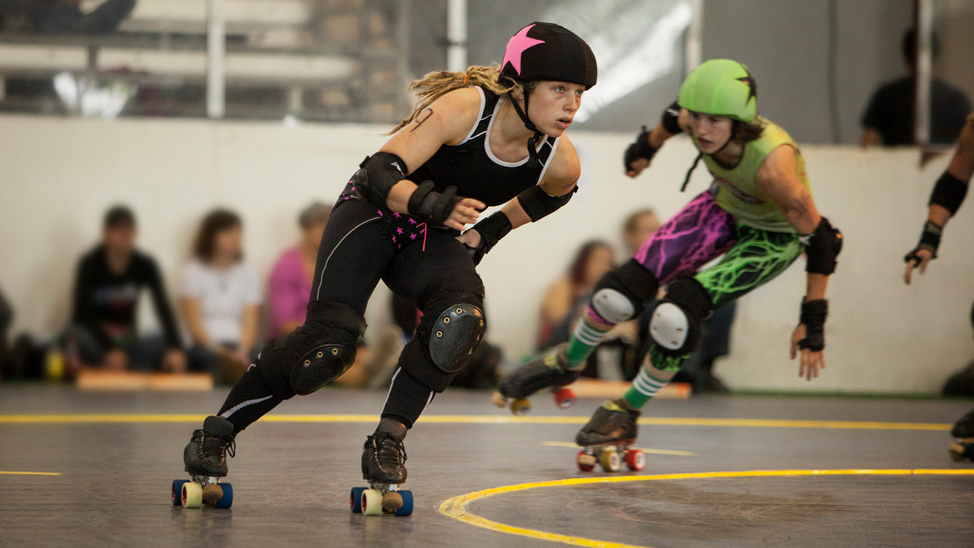Two women competing in roller derby.