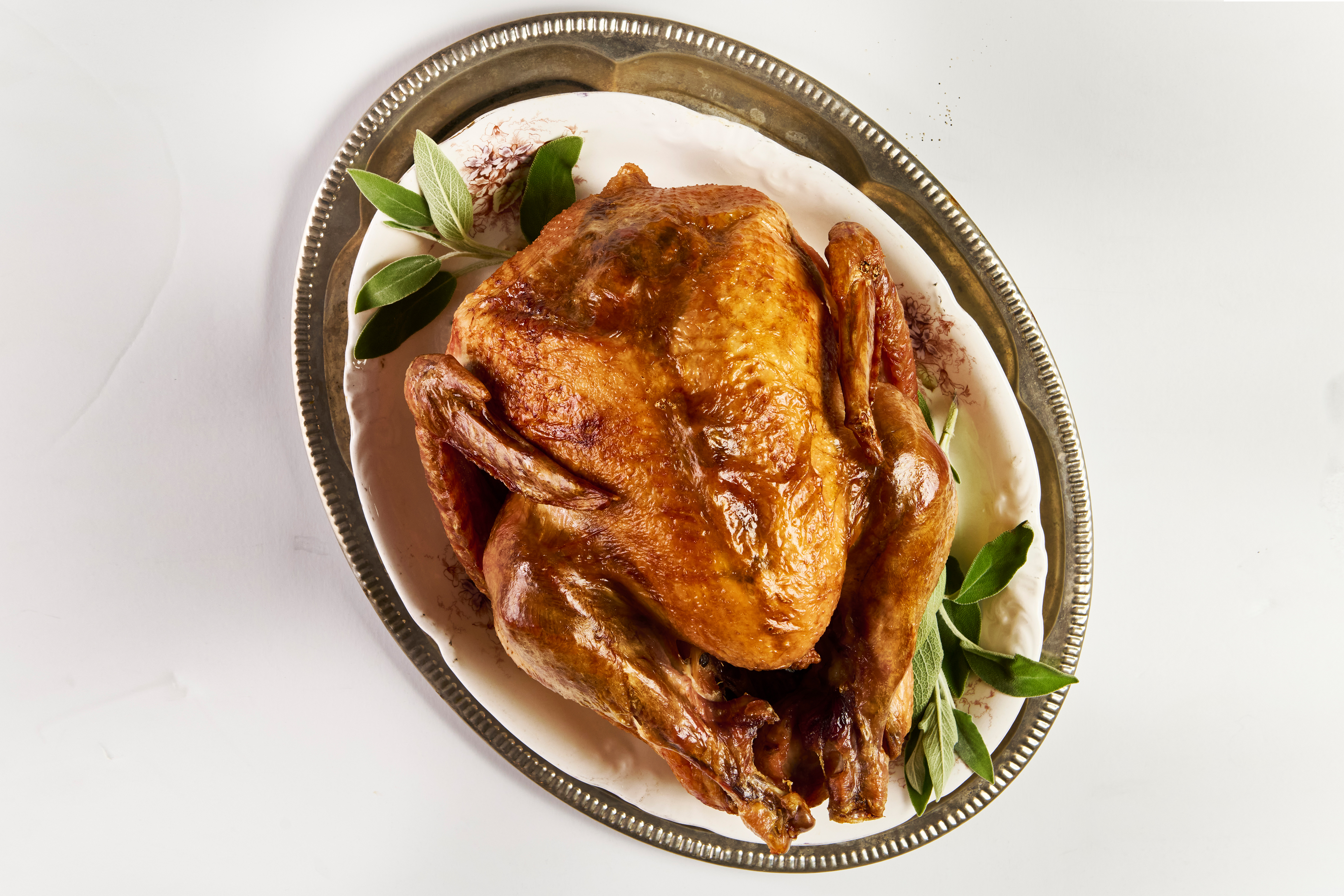 Thanksgiving turkey with greenery on a silver platter