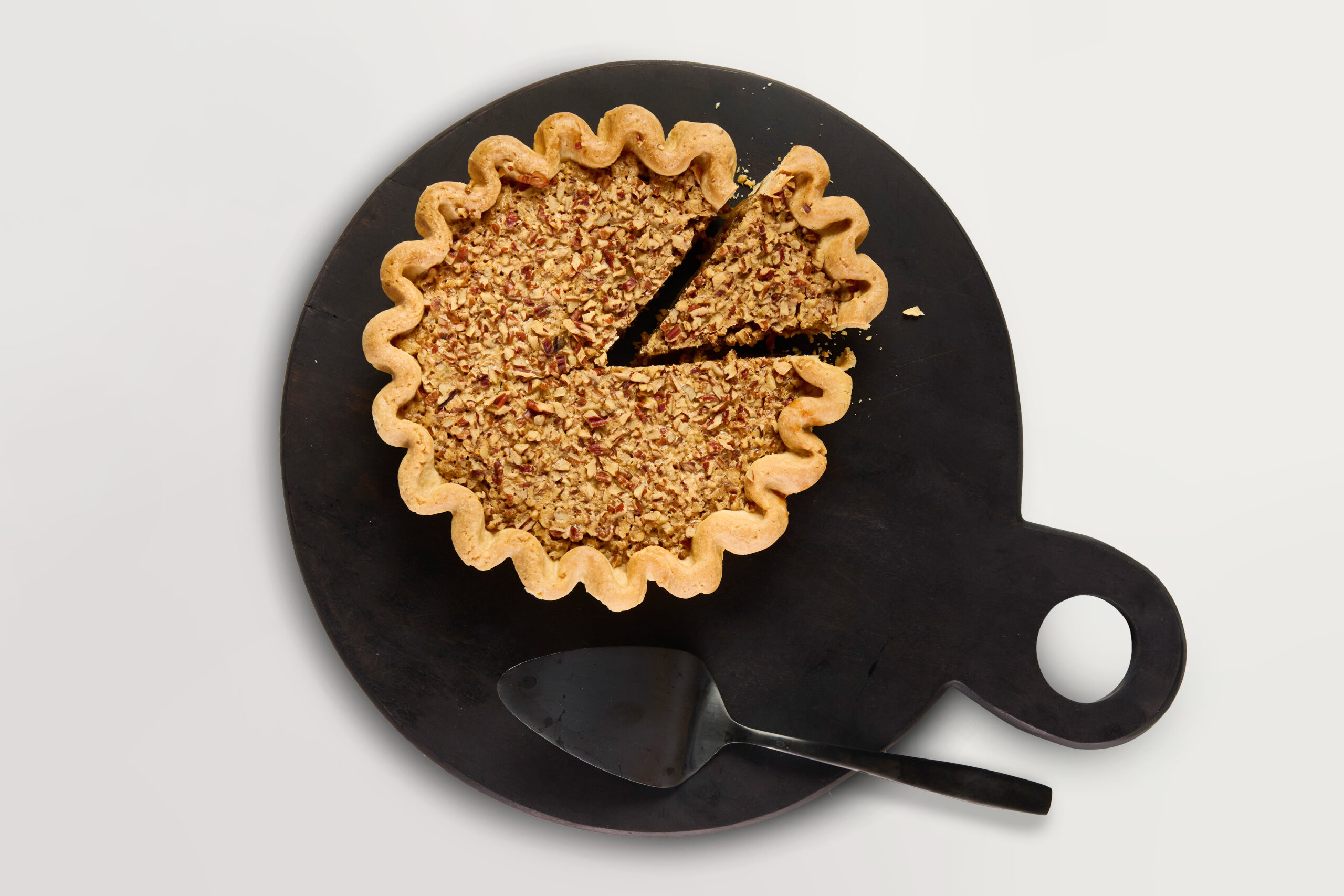 Emporium Pies' Drunkin' Nut pie on a black, round serving platter