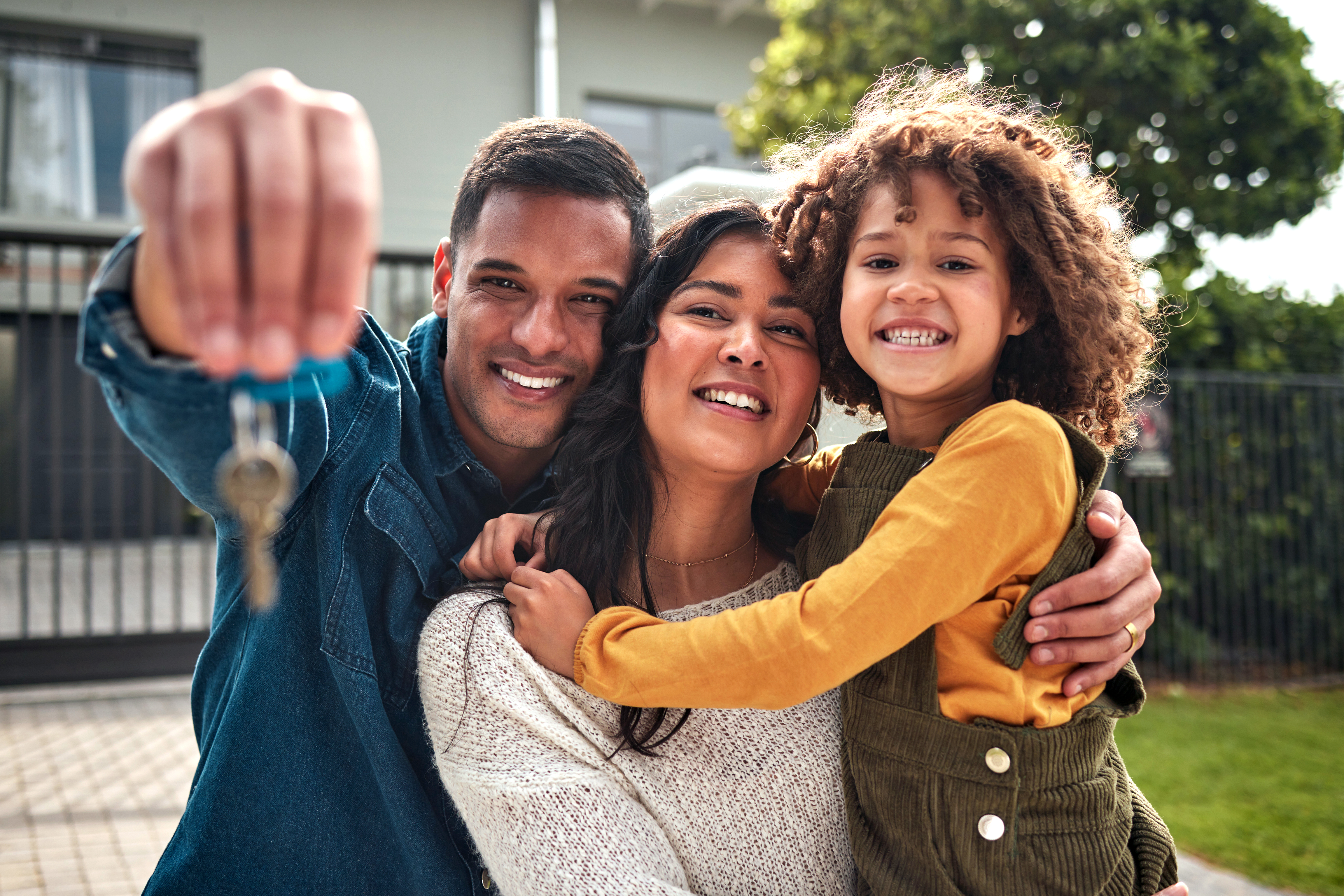 Man holding keys next to woman and child.