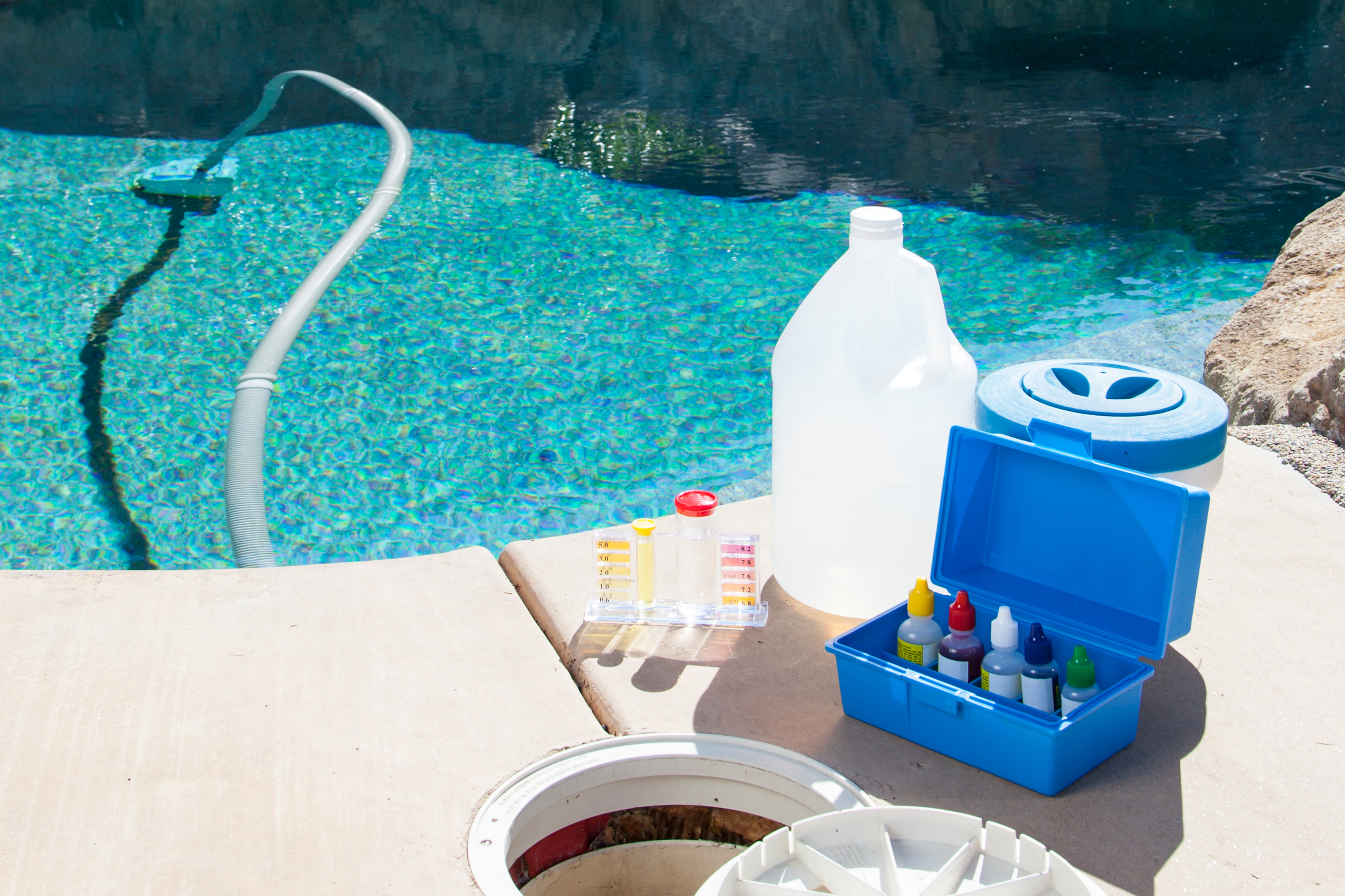 Pool chemical kit next to pool.
