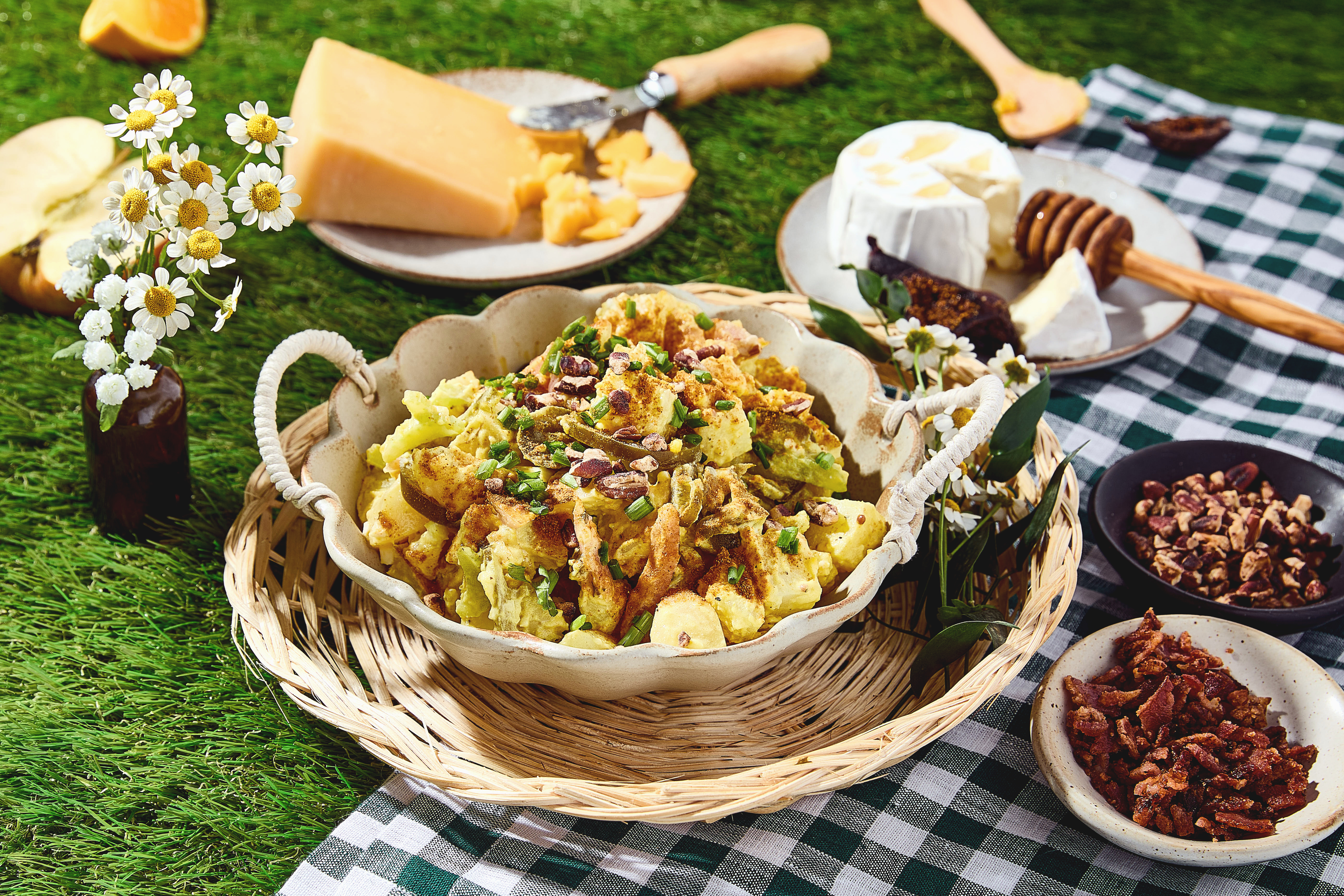 Potato salad in a bowl on a picnic blanket.