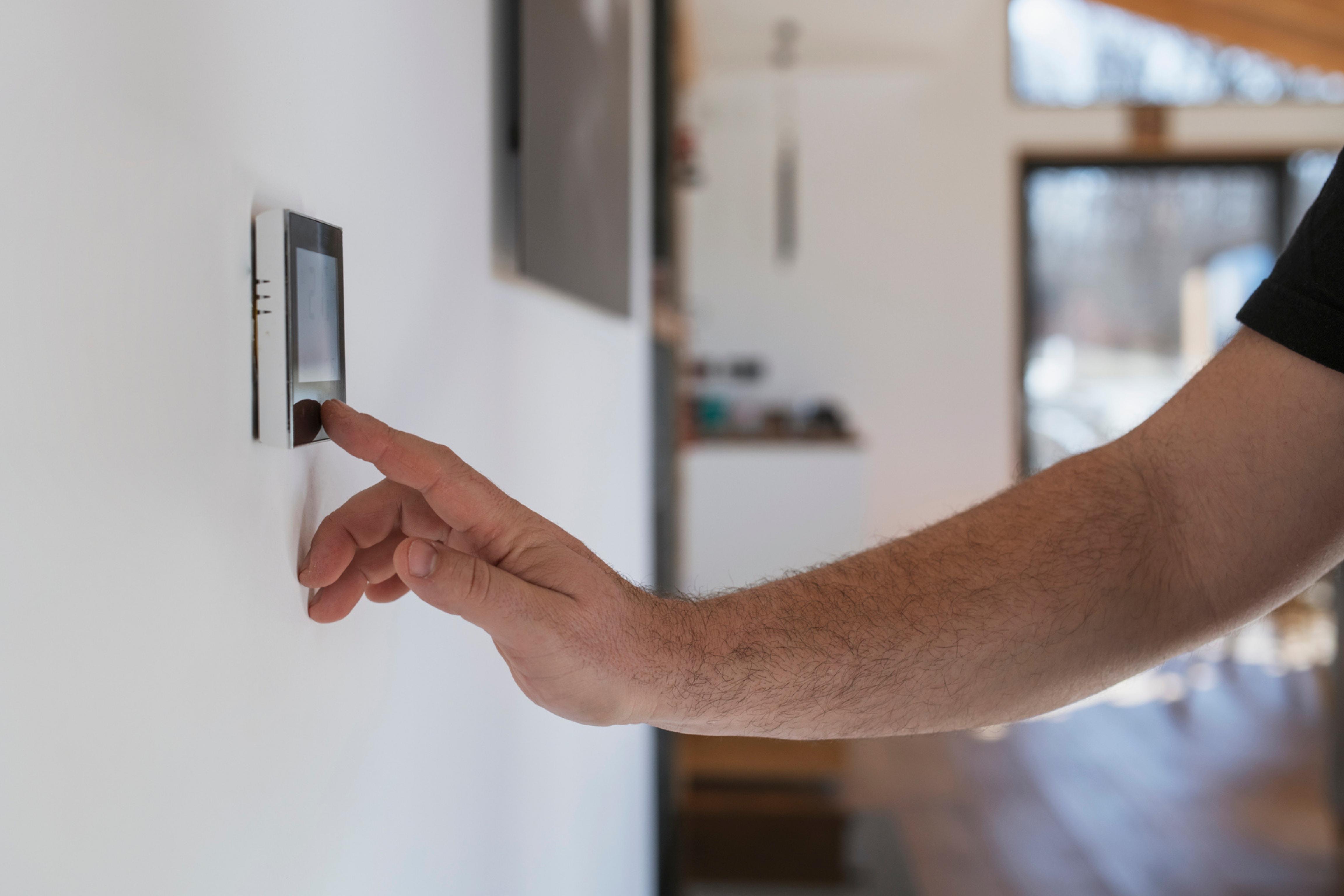 Man setting thermostat.
