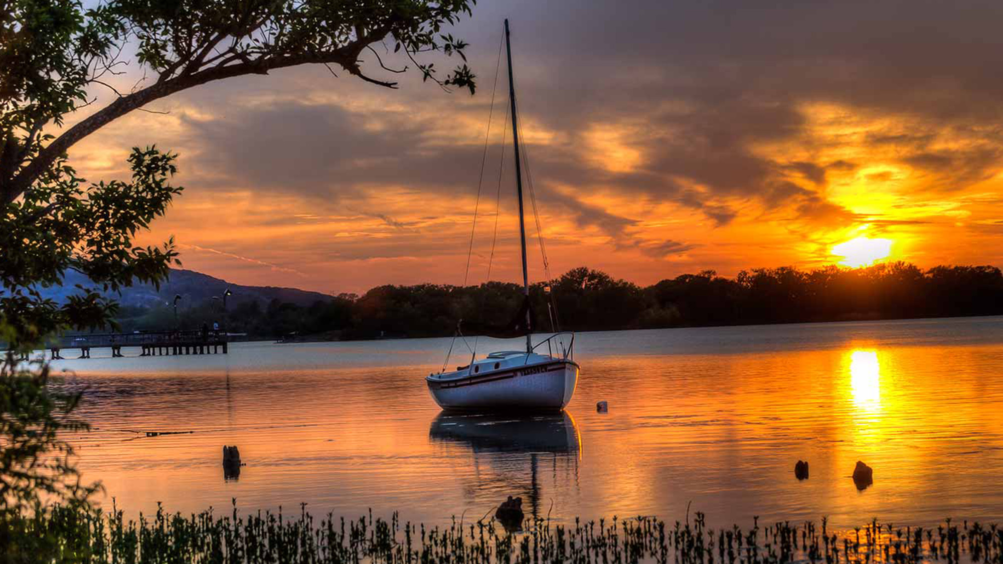 Sailboat on a lake at sunset.