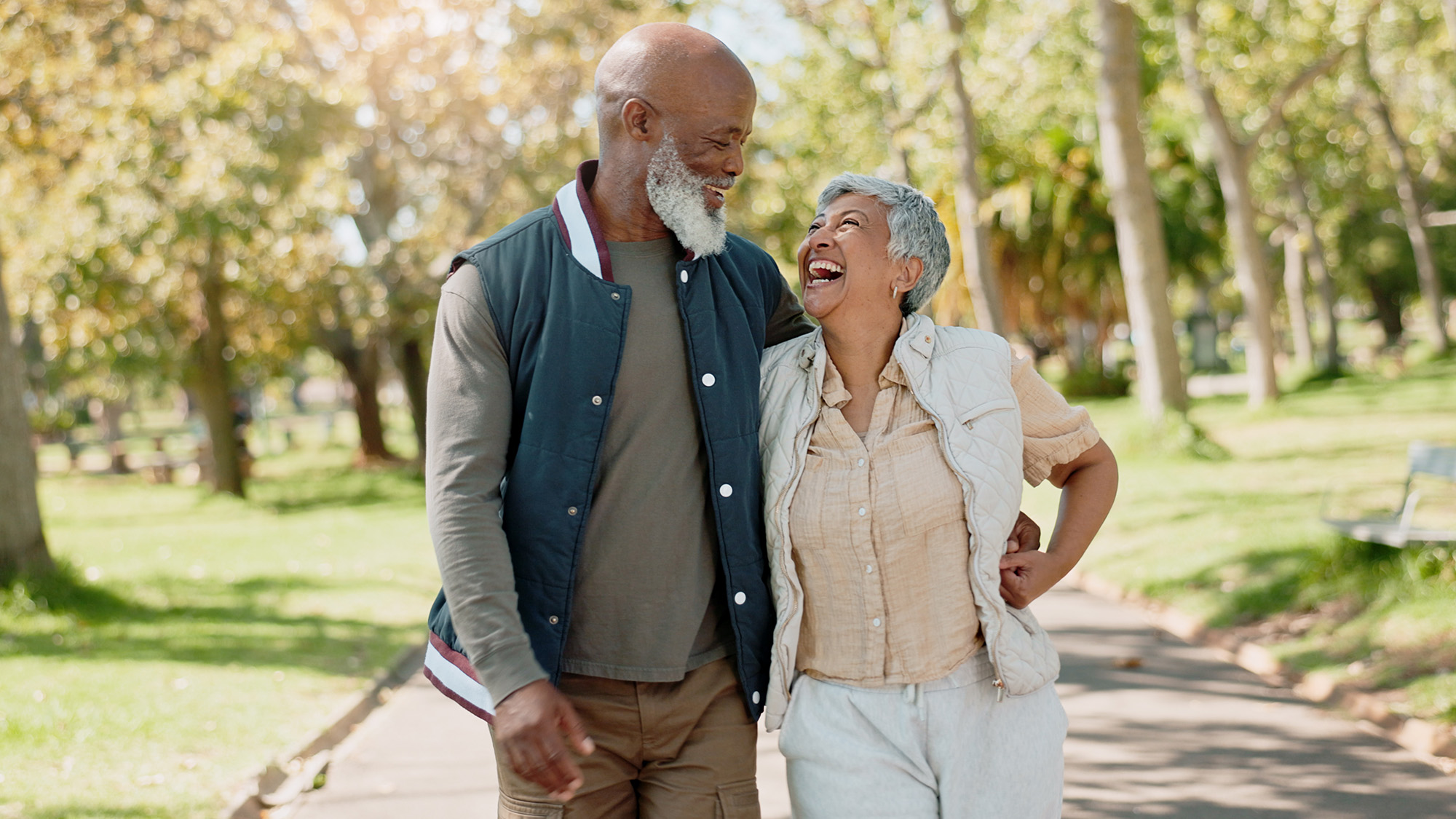Older man and woman walking in a park.