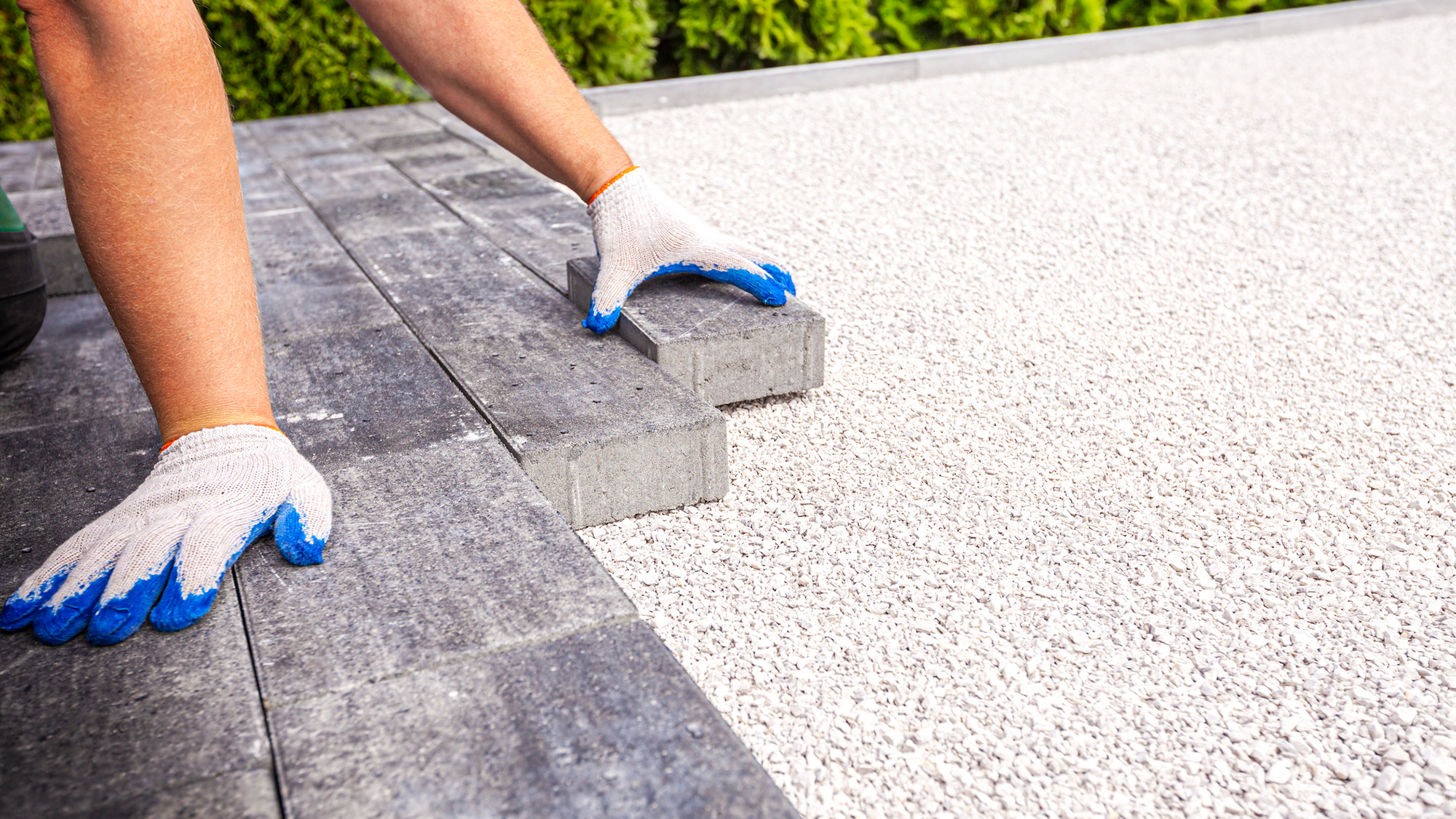 Man placing pavers for a driveway.
