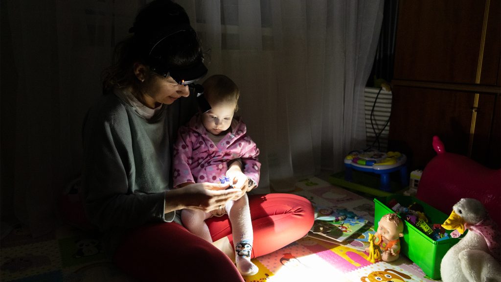 Adult and child playing with flash light during power outage.