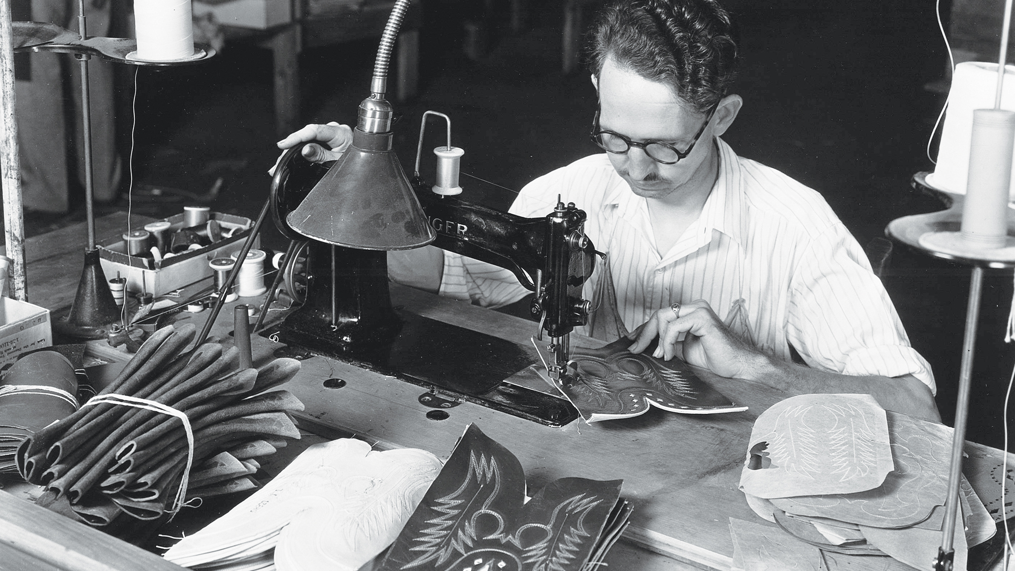Old images of man making cowboy boots for Justin Brands Inc.