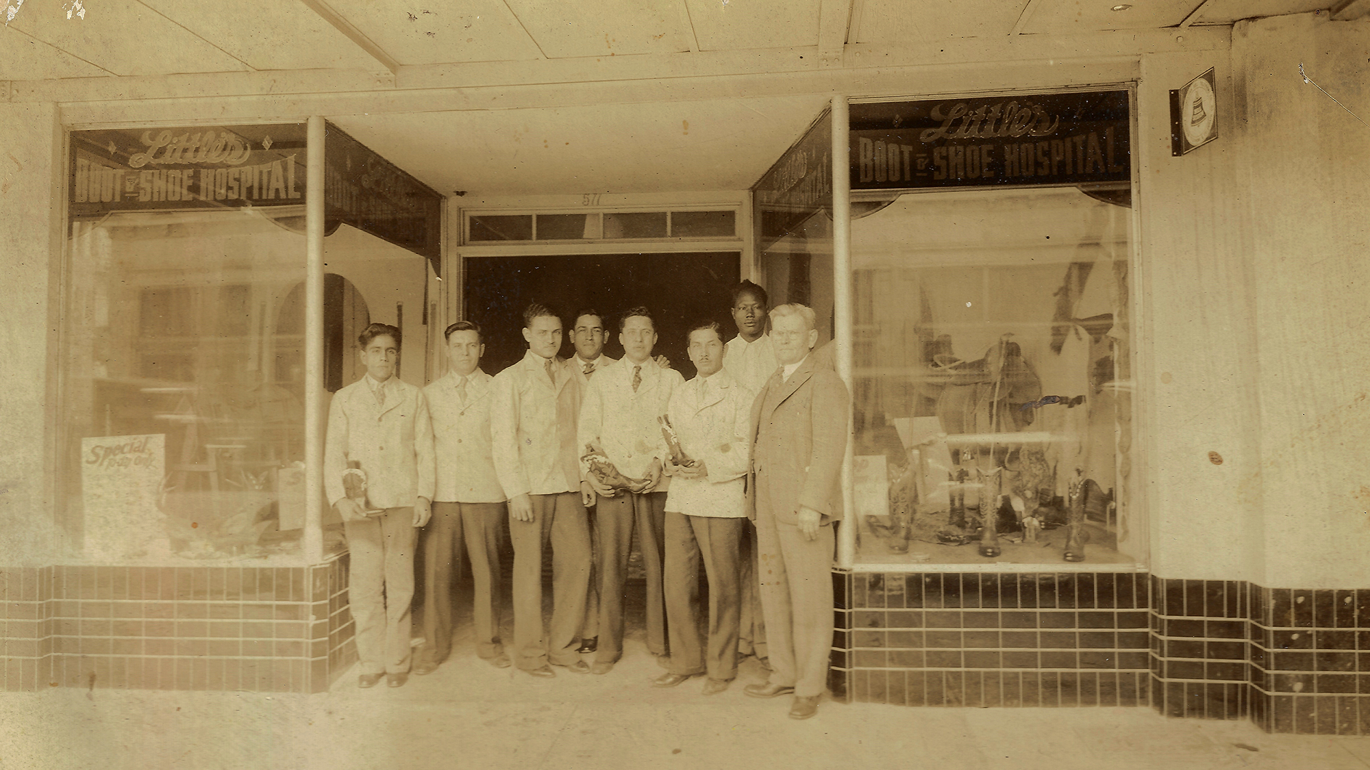 Old image of people standing outside of Little's Boot Company store.