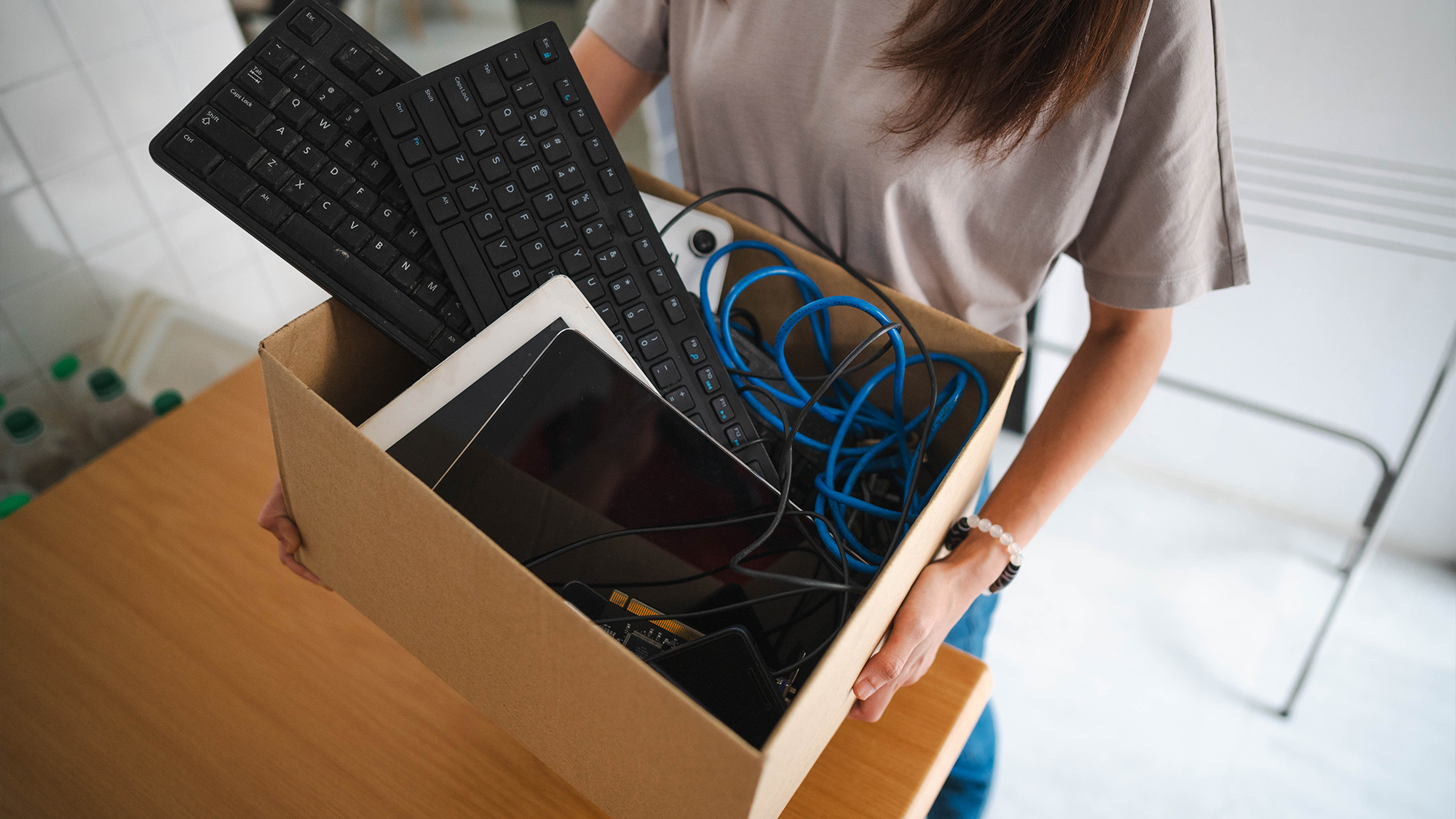 Person holding box of old electronics.