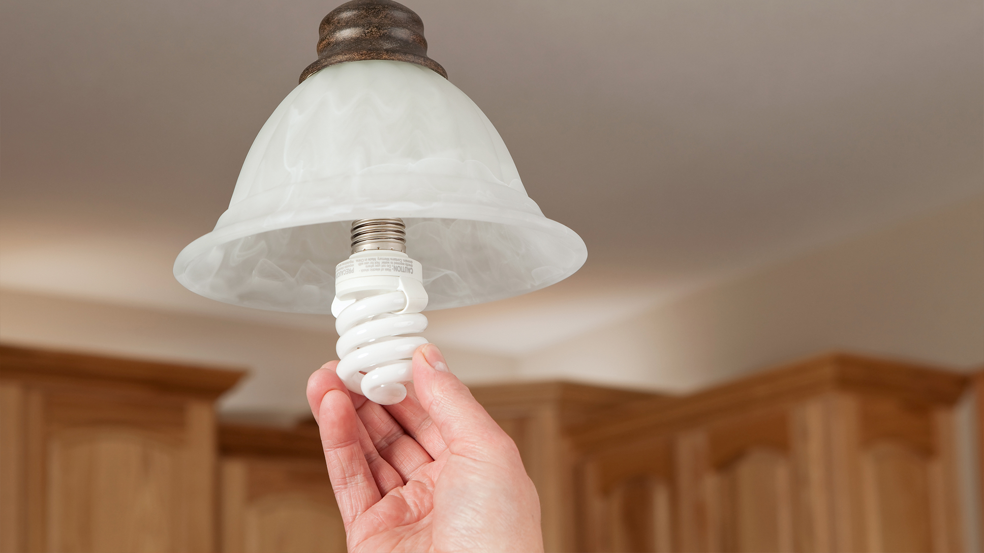 Person screwing in new light bulb.