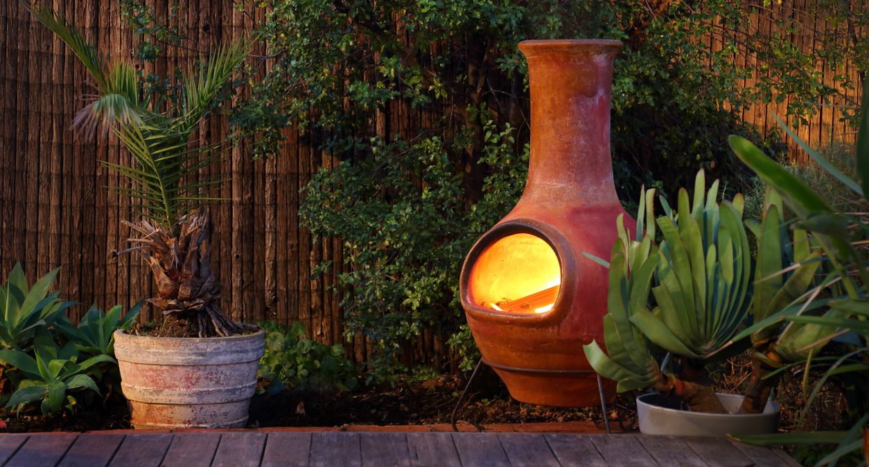 Chiminea with a fire going on a porch.