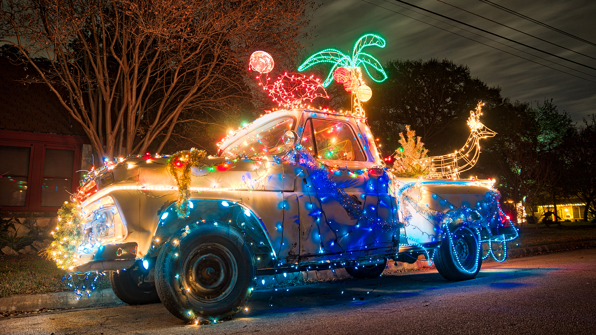 Car decorated with a lot of Christmas lights and decorations.