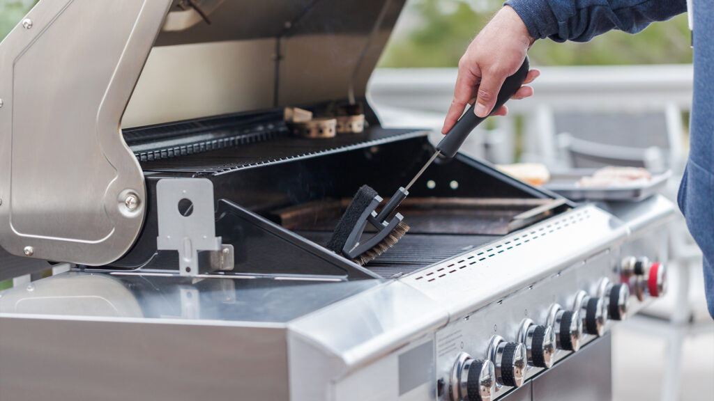 Person cleaning grill grates.
