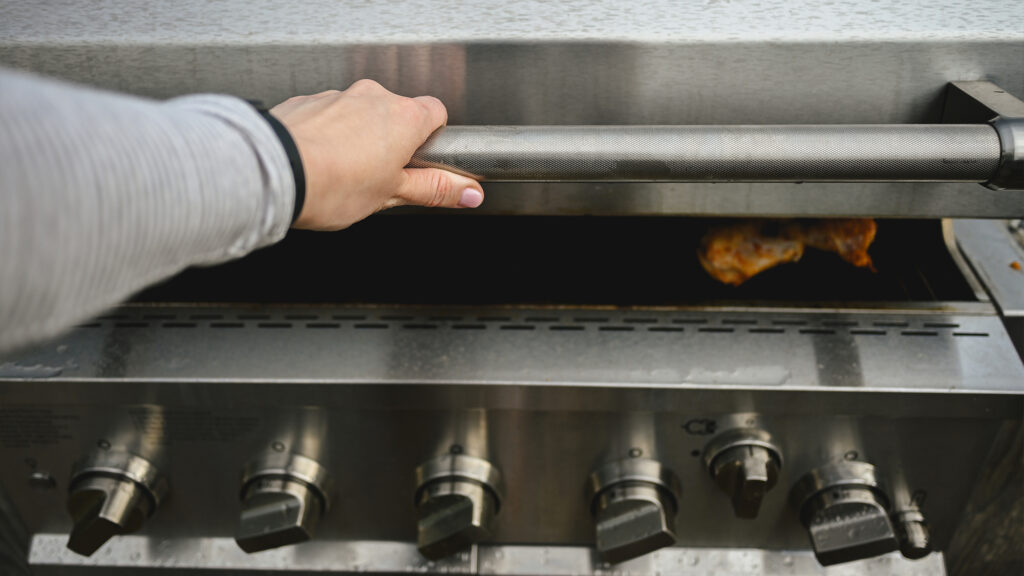 Person closing grill lid.