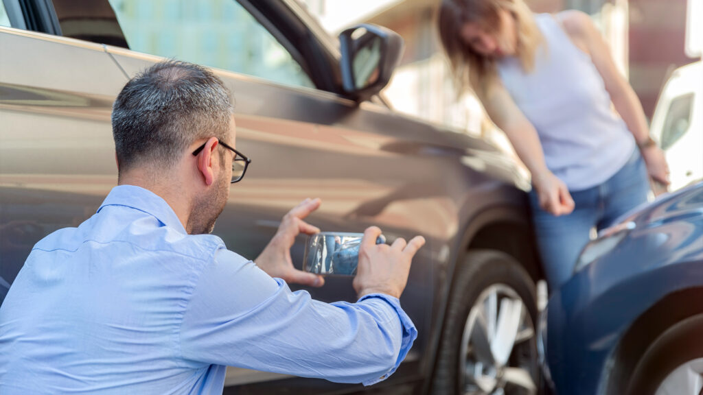 Person taking pictures of cars that were in a collision.