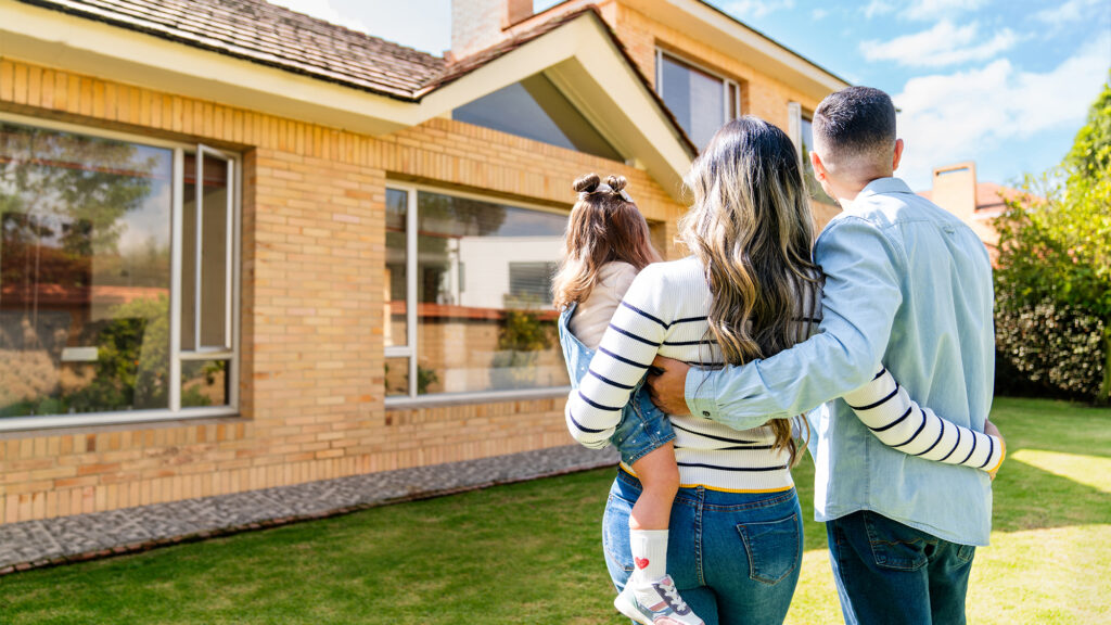Young family in front of a house.