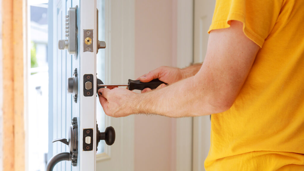 Person changing a door lock.