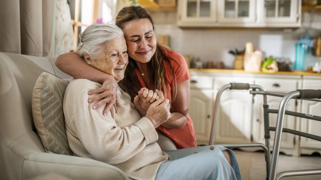 A woman holding an older woman.