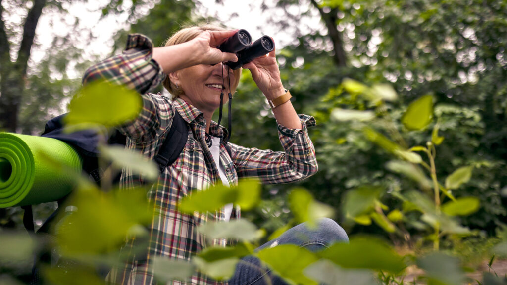 Person using binoculars outside.