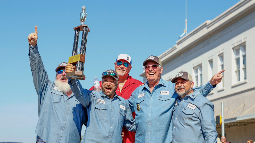 Group of men holding a trophy.