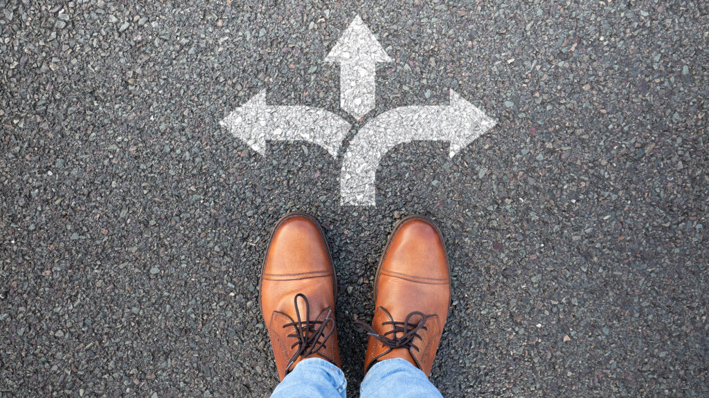 Person standing in front of arrow sign on the ground.