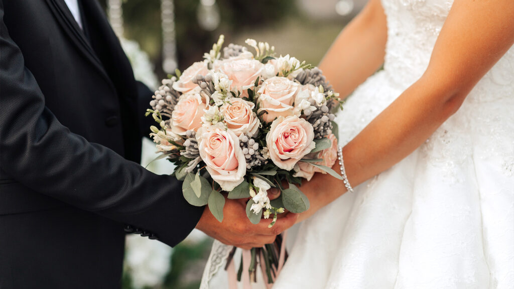 Bride and groom holding a bouquet.