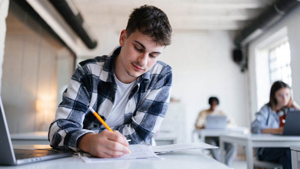 Man writing at a desk.